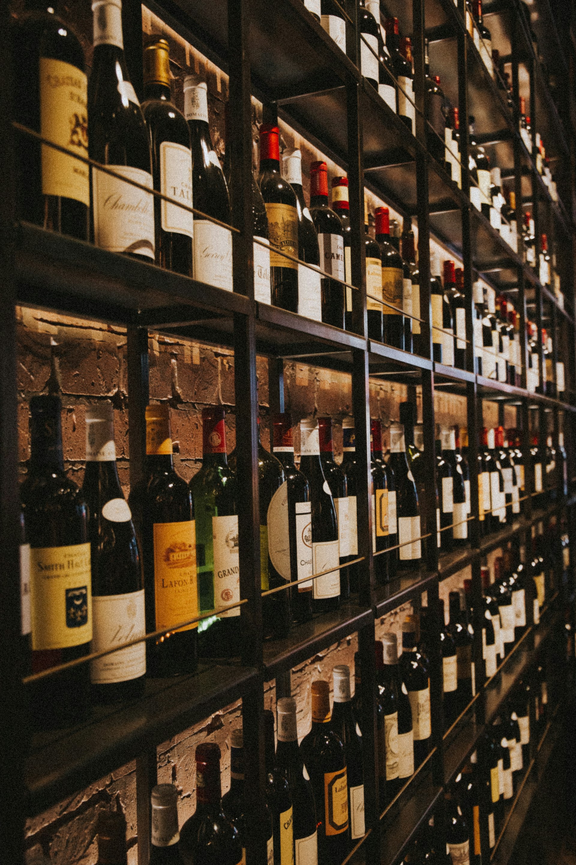 Wine bottles aging on wooden cellar rack